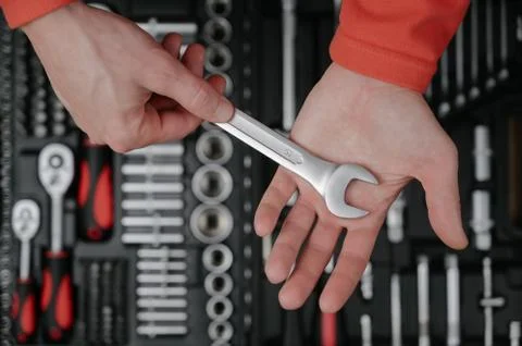 Hands of engineer worker holding socket chrome vanadium wrench spanner on bac Foto stock