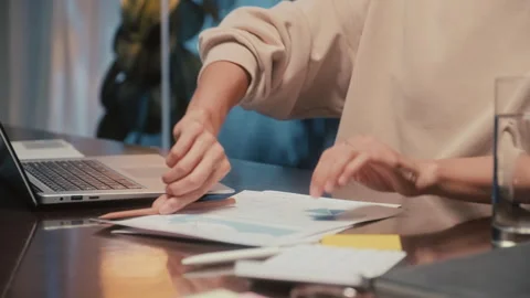 Hands of Entrepreneur Comparing Data on Laptop and in Report Stock Footage 248829950