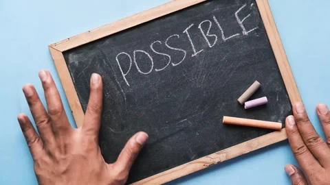Hands erase impossible word on chalkboard, changing it to possible with chalk Stock Footage 332579587