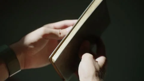Hands Examining a Dark Textured Notebook in Soft Light Stock Footage 322568497