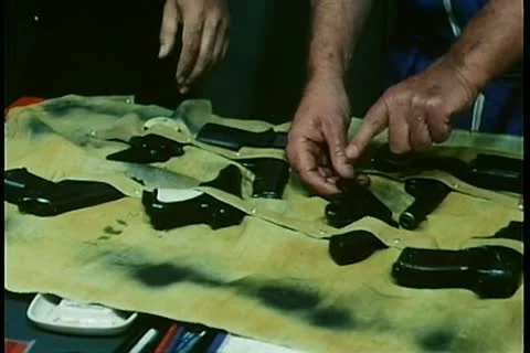 Hands examining different guns Stock Footage 11349658
