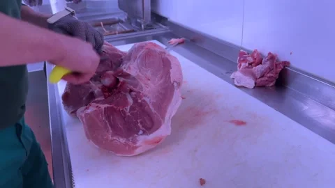 Hands of an Experienced Butcher Preparing a Cut of Fresh Meat on a Marble Table Stock Footage 303574951