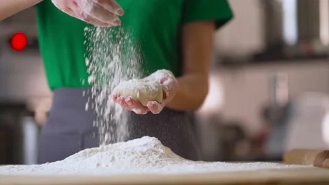 The hands of an experienced chef in a professional kitchen prepares dough and Stock Footage 189709598