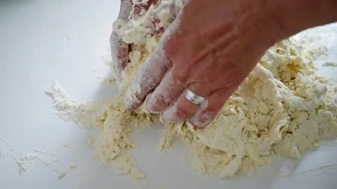 Hands expertly kneading dough on a clean work surface to create delicious baked Stock Footage 319313889