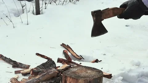 The hands of a farmer in black gloves with an ax cut a log in a snowy yard, Vídeos de archivo 234475281