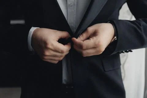 Hands fasten a dark suit jacket Foto stock