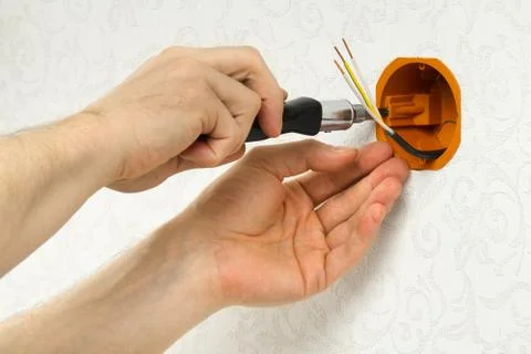 Hands fasten socket box to the wall Stock Photos