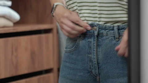 Hands fastening button on blue jeans Stock Footage 337833607