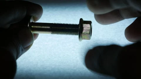 Hands Fastening Metal Hex Nut onto Threaded Bolt Stock Footage 340069654