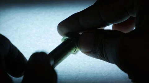 Hands Fastening Metal Hex Nut onto Threaded Bolt from Side Angle Stock Footage 340070112
