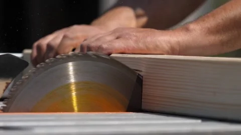 Hands feed wood into table saw as man builds planter from scratch Video stock 308018043