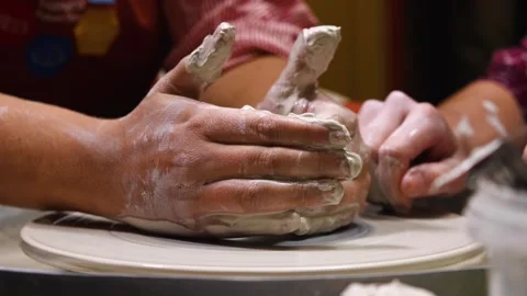 Hands of a female apprentice and hands of a master moulding a ceramic pot 스톡 동영상 243158972