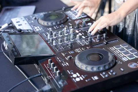 Hands of a female dj using a digital mixer. Stock Photos