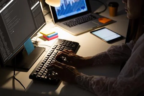 Hands of female programmer sitting at desk and using computer with coding on 库存照片