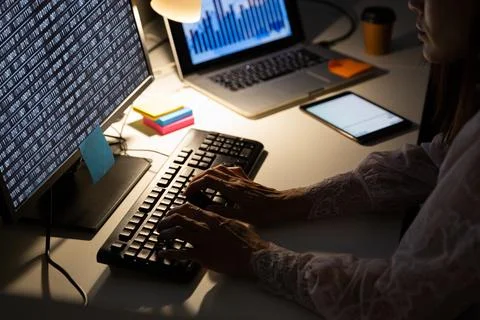 Hands of female programmer sitting at desk and using computer with coding on 库存照片