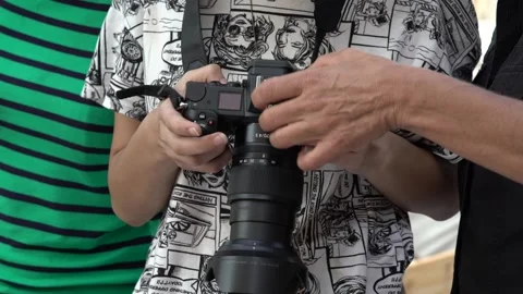Hands of female students with their instructor looking at a photocamera 스톡 동영상 140605853