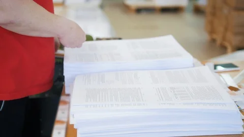 Hands of female worker sorting newspapers and puts on in stacks in the Stock Footage 89665022