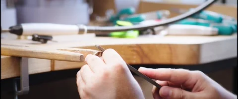 Hands Filing a Gold Ring on a Bench Pin at the Workbench Vídeo Stock 342562529