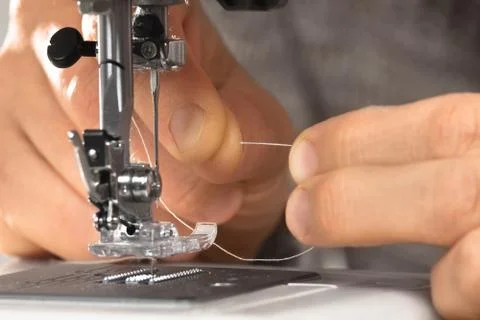 Hands fill the thread in the sewing machine Stock Photos