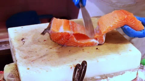 Hands of fishmonger processing fresh raw salmon, preparing fish fillet for sale 스톡 동영상 231761534