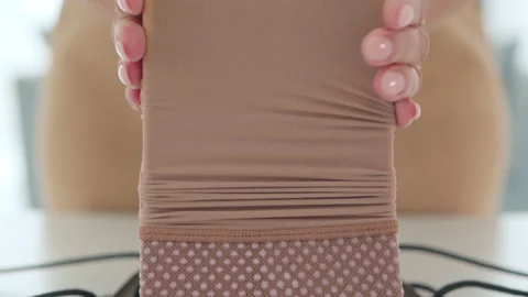 Hands fit a medical compression stocking onto a loading frame for daily home use Stock Footage 321710096