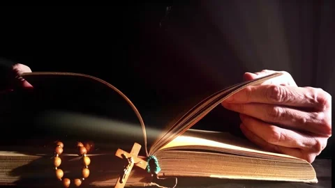 Hands flipping Bible in dark Stock Footage 255003965