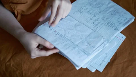 Hands flipping a math notebook with handwritten equations Stock Footage 342451089