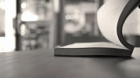 Hands flipping pages of a book placed on wooden table in the cafe. Stock Footage 121867010
