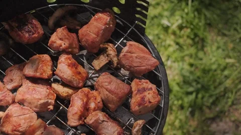 Hands flipping steaks on the grill for even cooking barbecue outdoors summer Stock Footage 310935527
