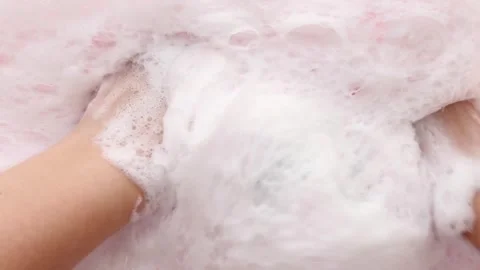 Hands in fluffy foam slowly squeeze the washcloth. Cleaning, body care. Part 3 Stock Footage 282729950