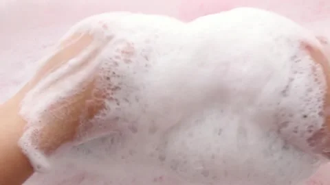 Hands in fluffy foam slowly squeeze the washcloth. Cleaning, body care. Part 4 Stock Footage 284528194