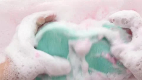 Hands in fluffy foam slowly squeeze the washcloth. Part 4 Stock Footage 311060758