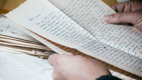 Hands fold and return old handwritten letters to opened mail envelope, Stock Footage 118335974