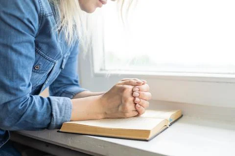 Hands folded in prayer on a Holy Bible for faith, spirituality and religion Stock Photos