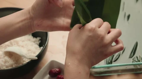 Hands Folding Bamboo Leaf for Traditional Rice Dumpling Preparation Stock-Footage 339069914