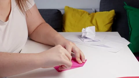 Hands folding bright sheet into delicate origami figure, origami process sh.. Stock Footage 320956396