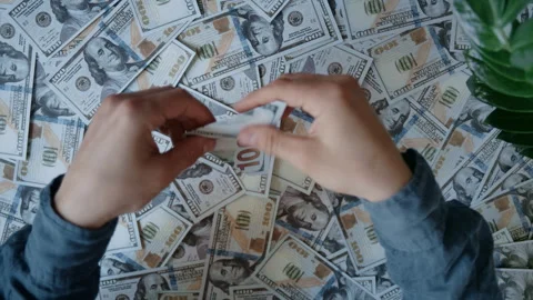 Hands folding a hundred dollar bill into a paper airplane Видео 336709886