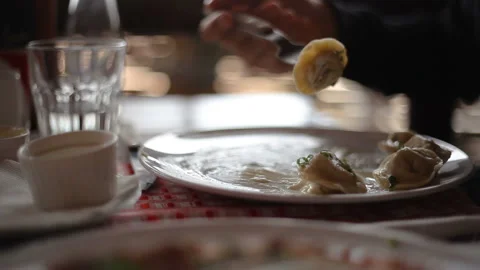 Hands with a fork eating Russian dumplings, plate, restaurant Video stock 150274709