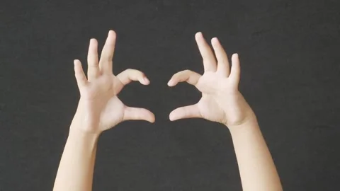Hands forming a heart shape gesture against a dark background Vidéo 347659527