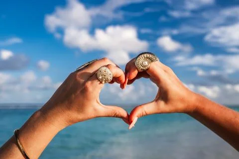 Hands forming a heart shape at the ocean beach in Maldives Stock Photos