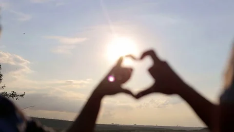 Hands forming a heart shape on sunset, silhouette. Stock Footage 78587970