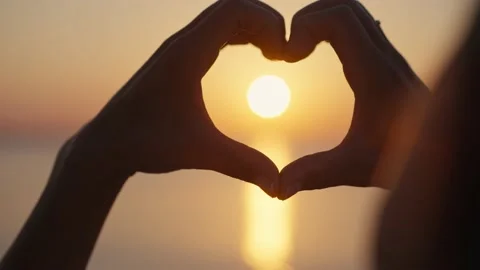 Hands forming a heart shape with sunset silhouette. Vídeos de archivo 219376641