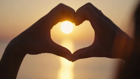 Hands forming a heart shape with sunset silhouette. Stock-Footage 219749734