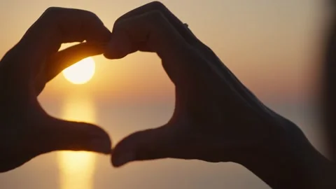 Hands forming a heart shape with sunset silhouette. Stock Footage 219749961
