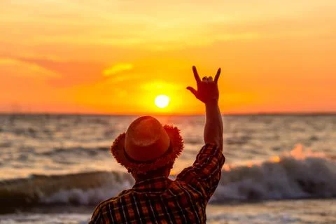 Hands forming a love sign with sunset on the beach with sunset. Stock Photos