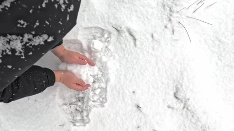Hands forming small snowball during winter daytime scene Stock Footage 322684082