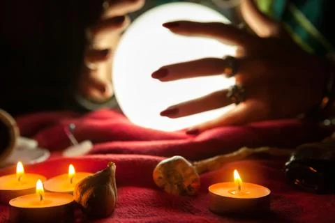 Hands of fortune teller witch in front of crystal ball Stock Photos