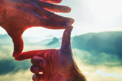 Hands framing view distant over sunset, vintage filter. Stock Photos