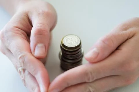 Hands gently enclosing stack of coins, protection of savings, financial sec.. Foto stock