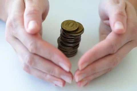 Hands gently enclosing stack of coins, protection of savings, financial security Foto stock